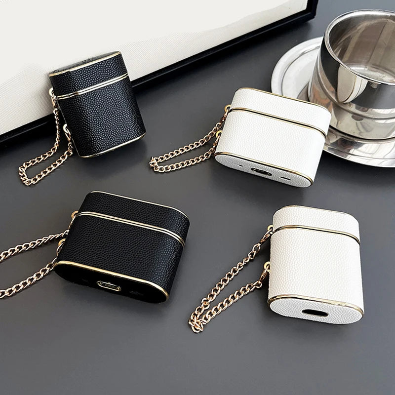 Wrist strap AirPods case set: dark (obsidian) and white (pearl) with gold chain.