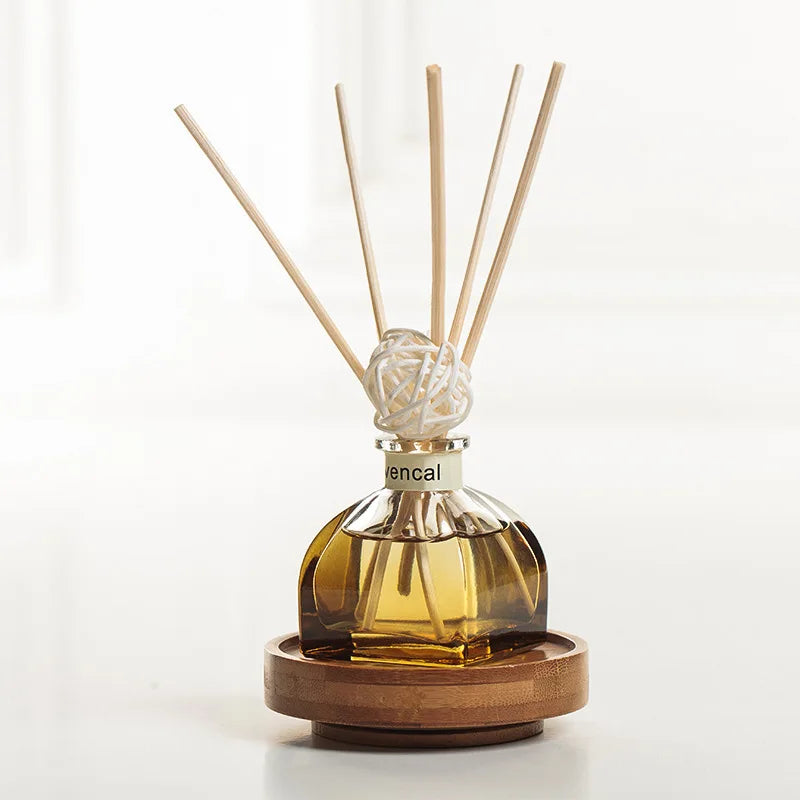 Amber floral reed diffuser bottle with 5 light wooden reeds and white woven ball