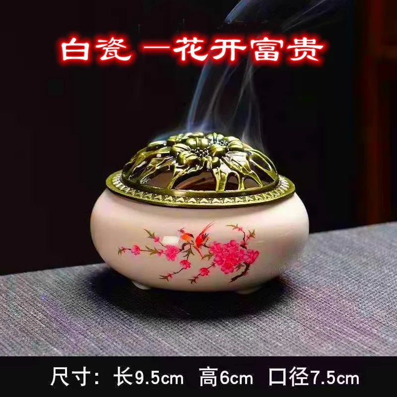 White ceramic incense burner with floral print and ornate gold lid