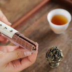 Incense burner on a stand with decorative boshan top, shown with lingering smoke.