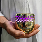 Seven-Light electric bakhoor burner in gold, purple-lit hex grille, held in hands