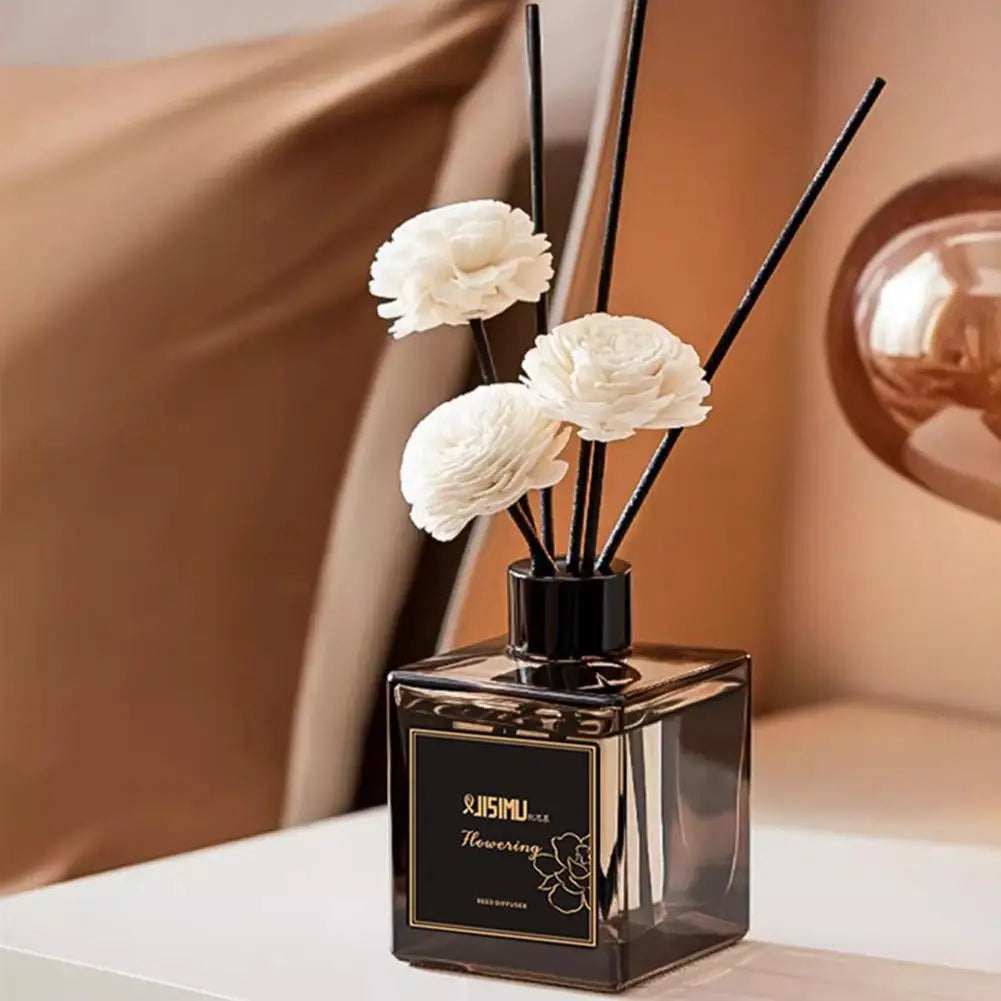 Mini reed diffuser bottle with black reeds and white flower heads, 50ml