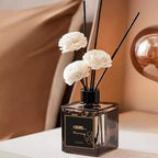 Mini reed diffuser bottle with black reeds and white flower heads, 50ml