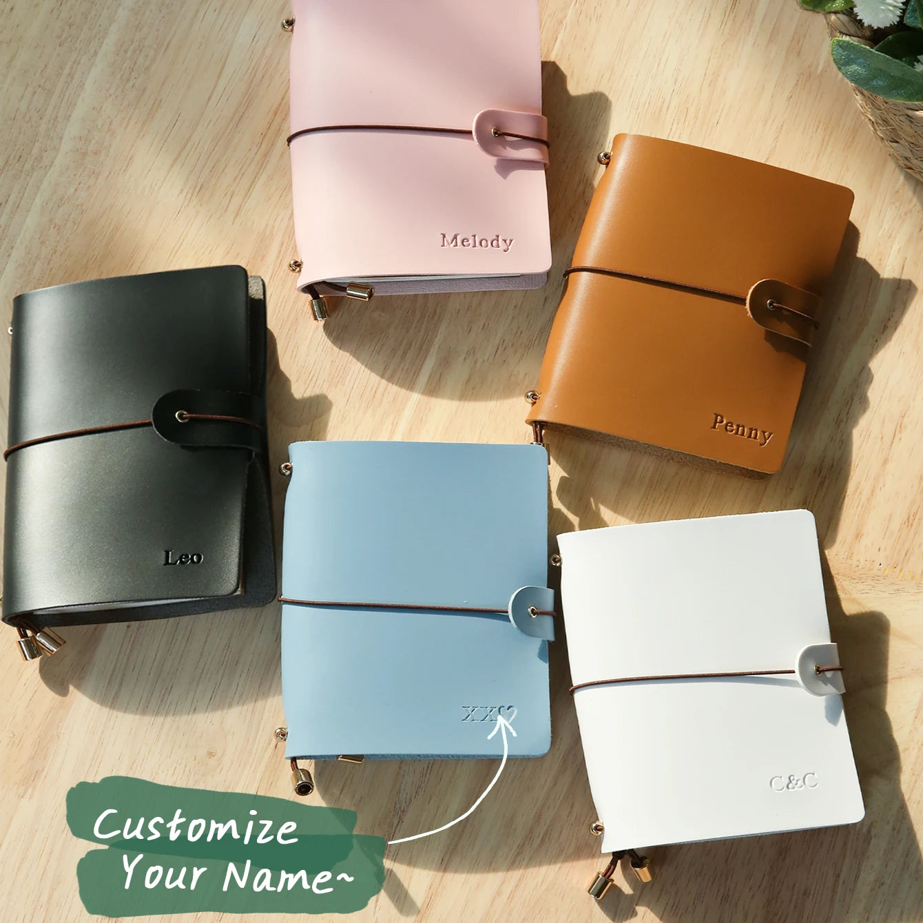 Multiple vegan leather passport holders in green, pink, orange, blue, and white with buckle straps