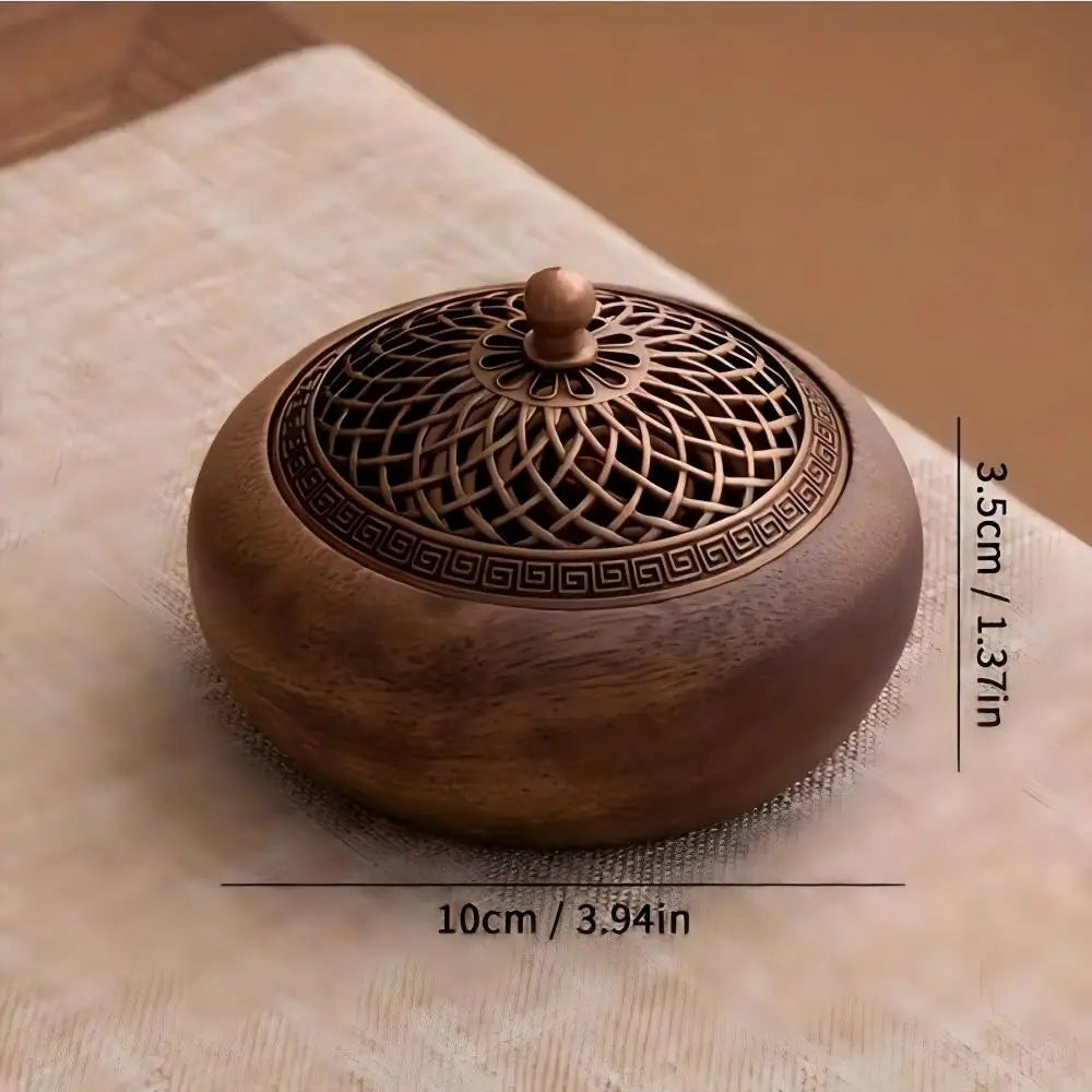 Round solid wood incense tray with decorative metal grille and central knob, on tabletop