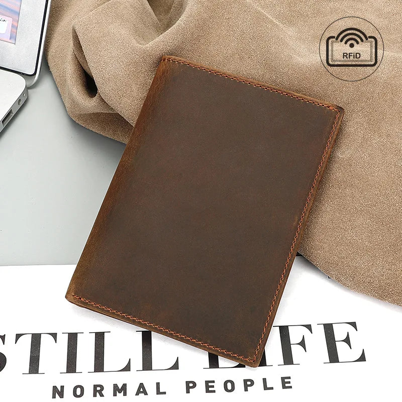 Compact travel document wallet in cognac brown with stitched edges and RFID mark.