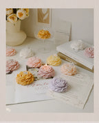 Peony sculptural candle variety with lit wicks, floral shapes arranged with cards