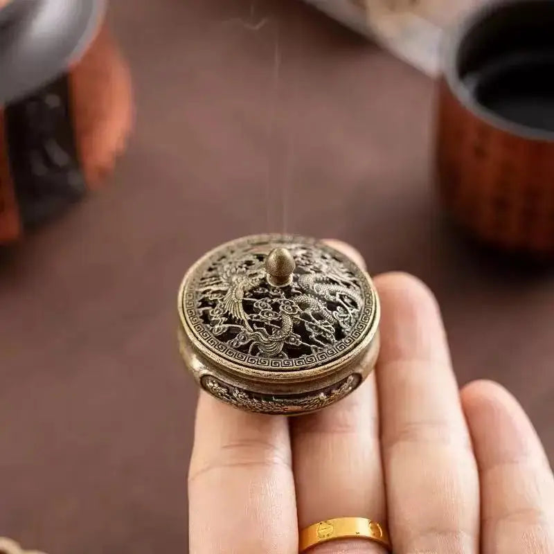 Round engraved incense plate burner lid held in hand, golden dragon relief detailing