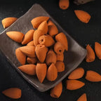 Orange backflow incense cones in a clear plastic pouch, cones loose around it
