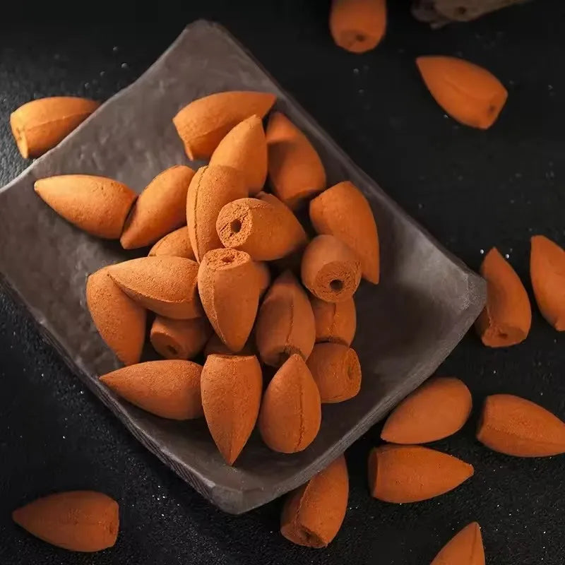 Orange backflow incense cones in a clear plastic pouch, cones loose around it