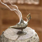 Incense burner with conical lid and curved handle, smoke plume above pedestal