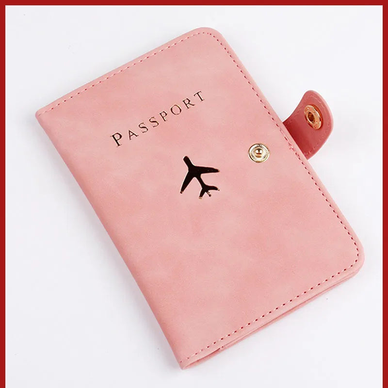 Blush pink passport folio with airplane logo, snap button closure, stitched border