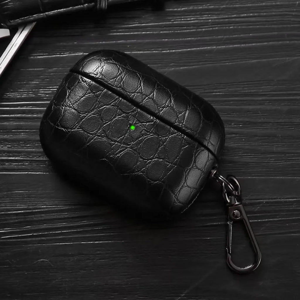 Black crocodile-grain AirPods case with keyring clip, angled view