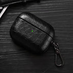 Black crocodile-grain AirPods case with keyring clip, angled view