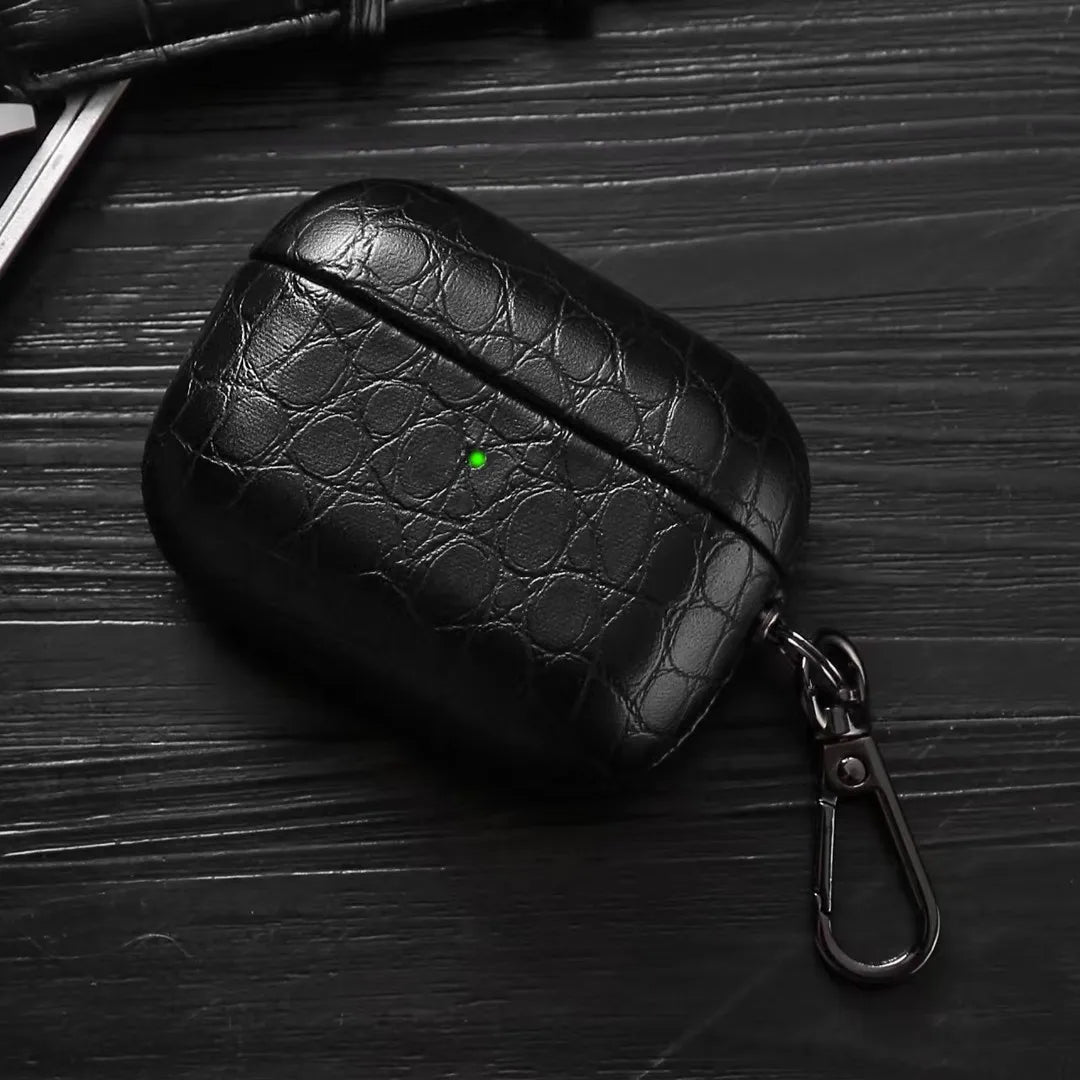 Black crocodile-grain AirPods case with keyring clip, angled view
