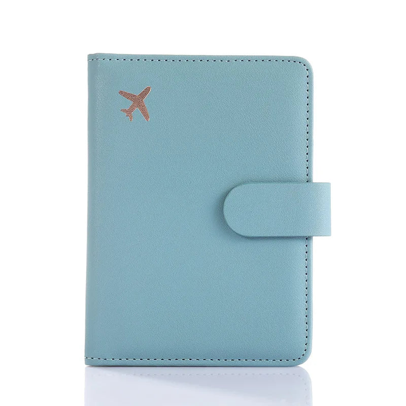 Light blue passport folio with snap strap closure and embossed airplane icon