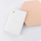 Ivory white passport sleeve with stitched edges and gold plane logo