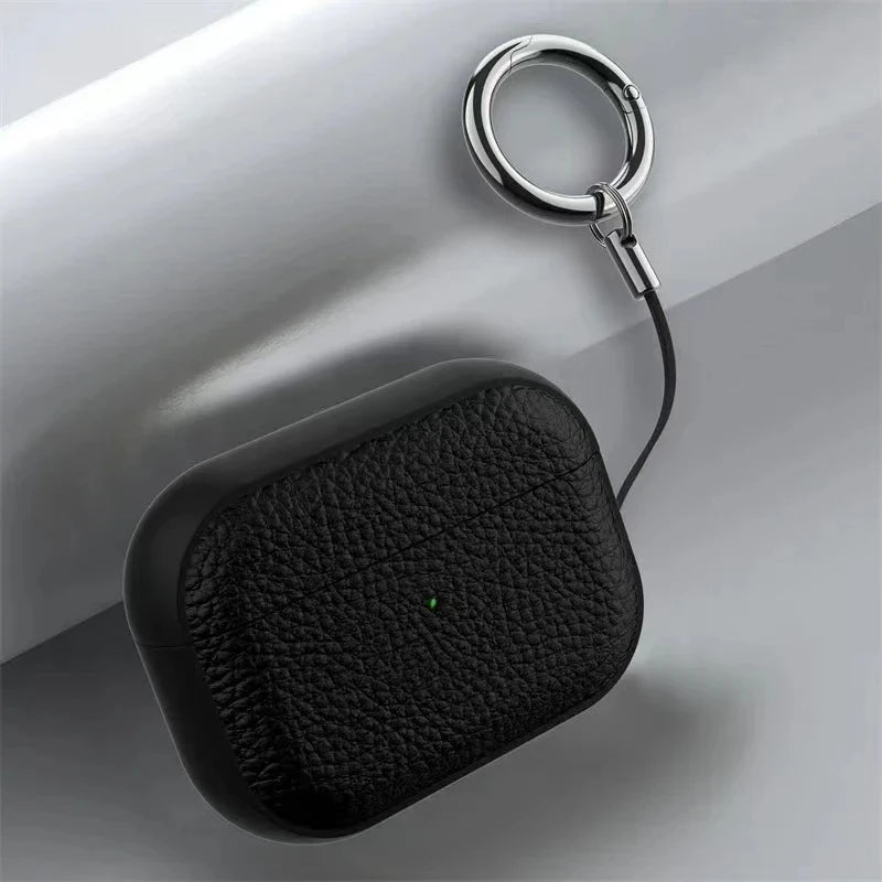 Black leather AirPods keyring case close-up with small status dot and metal key ring