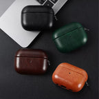 Orange, dark brown, and black leather AirPods cases with metal keychain clips