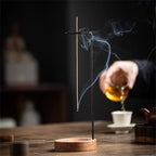Walnut-black inverted incense holder with incense stick and rising smoke
