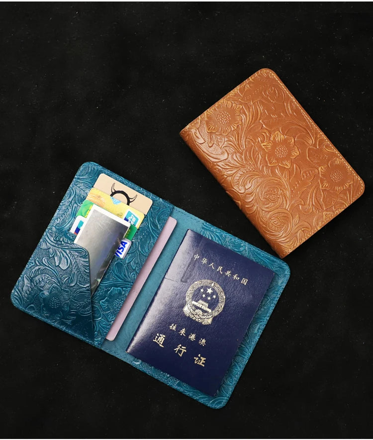 Blue and cognac brown leather travel folios with embossed floral details, held open for view.