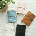 Vegan leather passport holder set in light blue, pink, tan, white, and black with snap straps