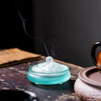 Cobalt glass incense vessel on wood, arched lid pattern with smoke