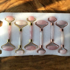 Pink rose quartz glow rollers with rounded stone heads and gold-tone frames