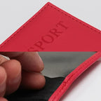 Red passport sleeve with embossed “PASSPORT” and visible top stitching along the edge