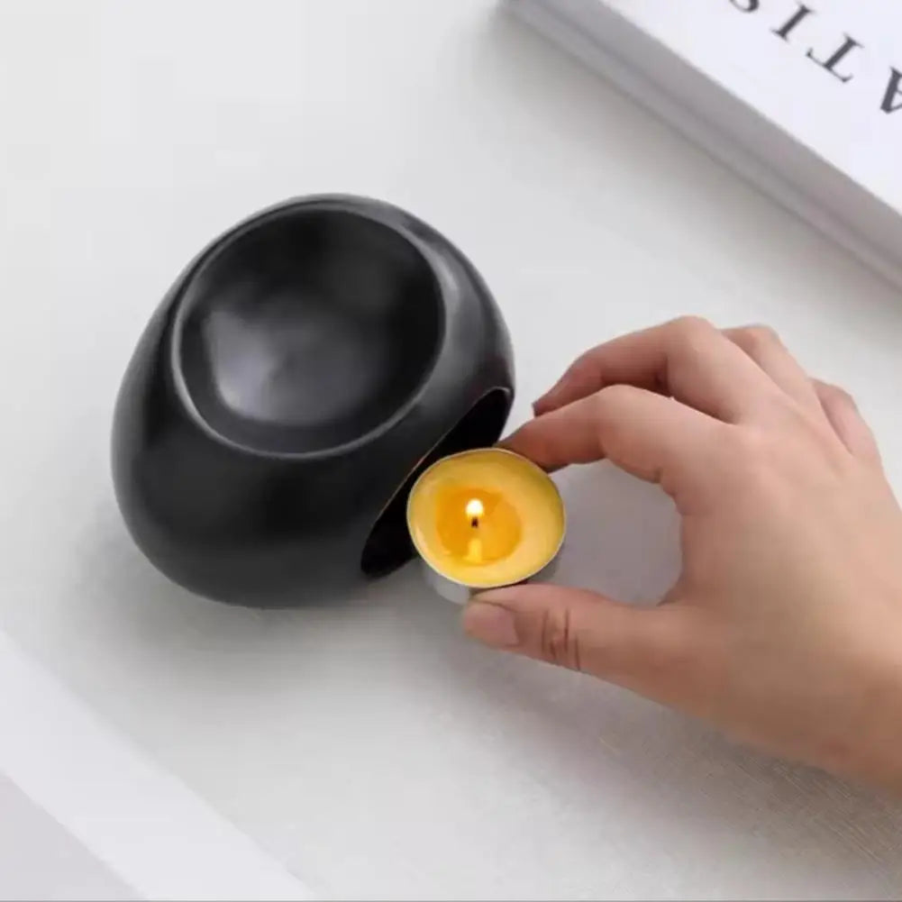Black ceramic aroma oil burner with large opening, oil-lamp insert held nearby