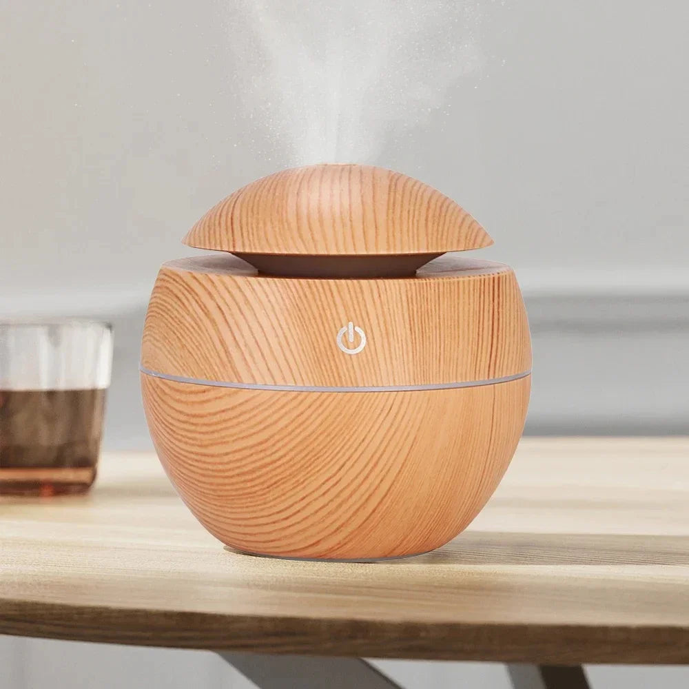Wood-grain humidifier diffuser front view, domed top with small power indicator.
