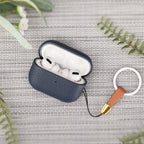Dark blue leather AirPods Pro case with lid open, earbuds inside and key ring attached