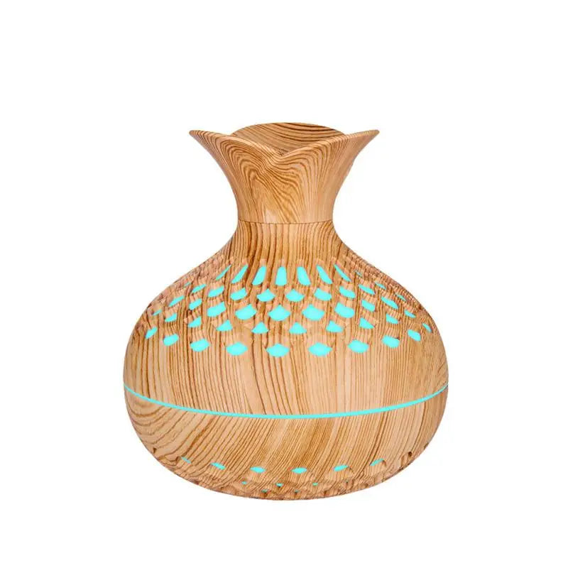 Light wood grain mini vase humidifier with teal light dots in the cutout vent pattern