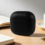Obsidian black eco-leather AirPods case, rounded clamshell lid with small front opening