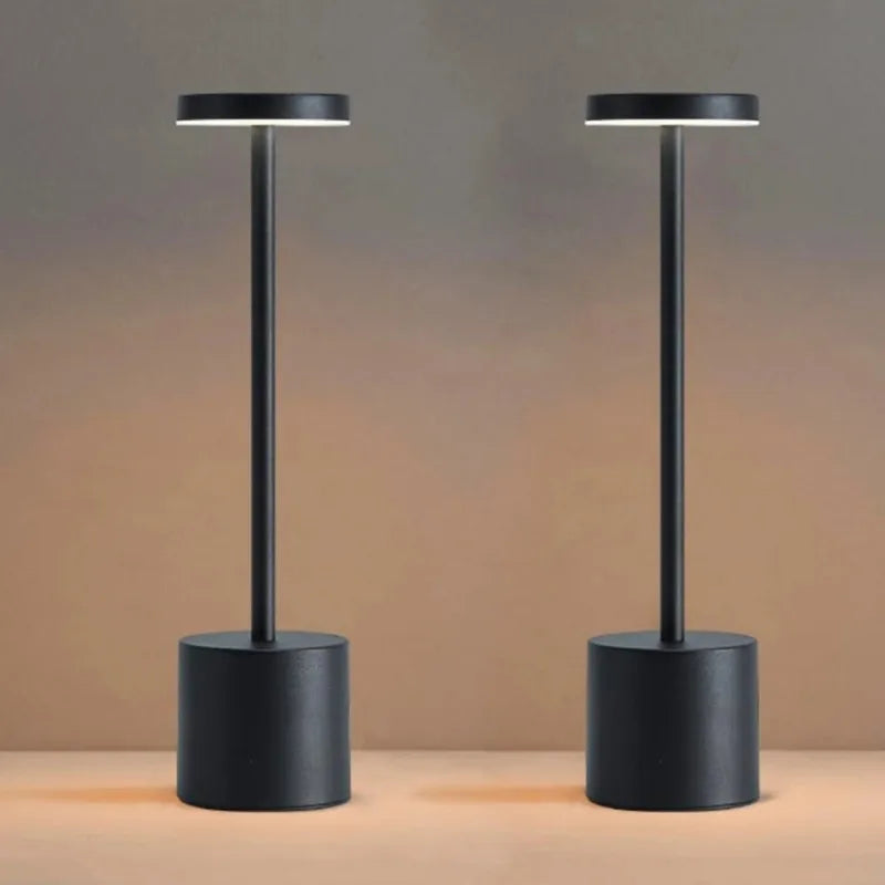 Obsidian portable LED touch lamp: dark cylindrical base with straight metal stem, lit top