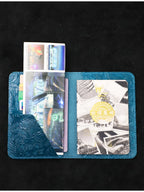 Blue leather travel folio open, card slots holding multiple travel cards and tickets