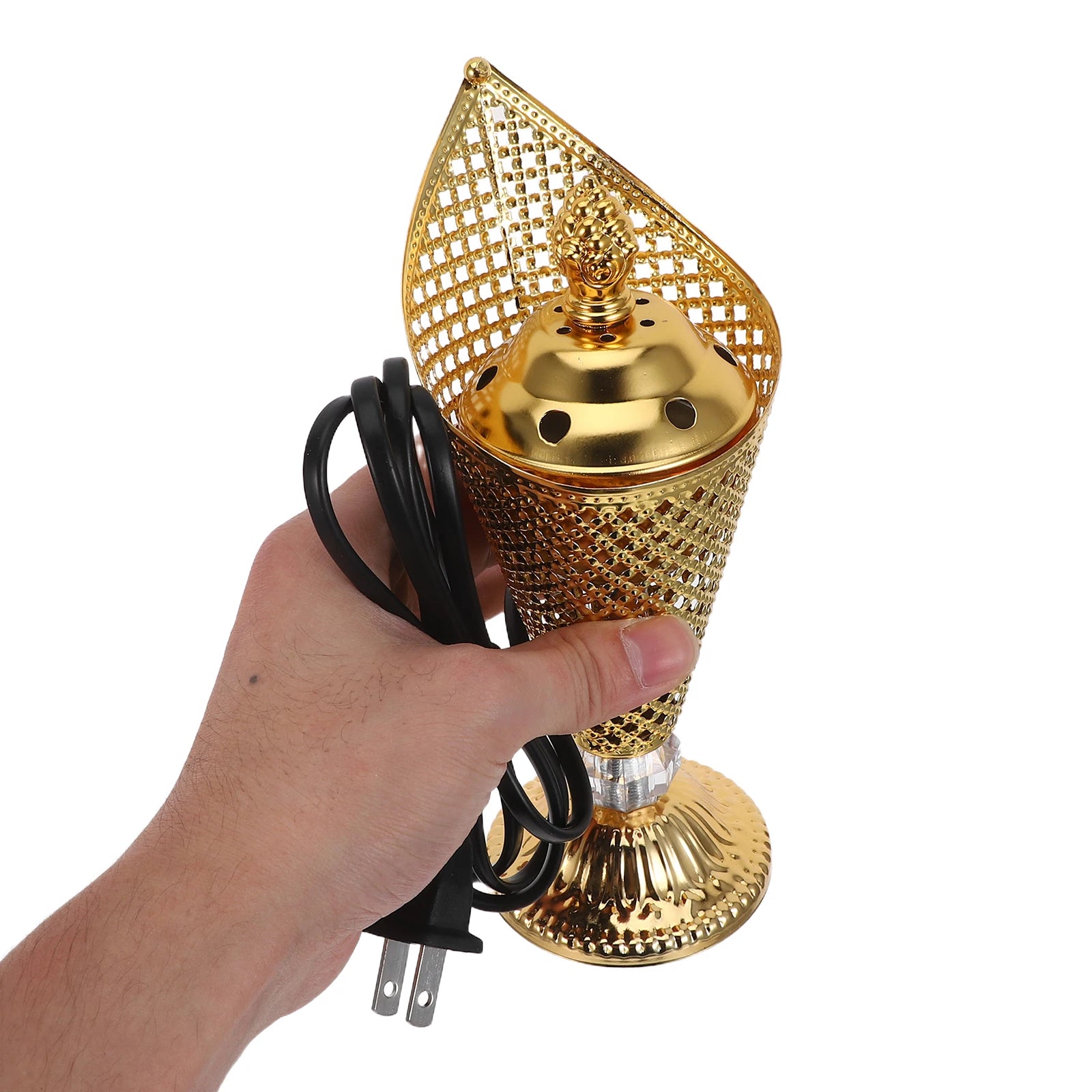 Gold electric mabkhara held in hand with black plug cord and base