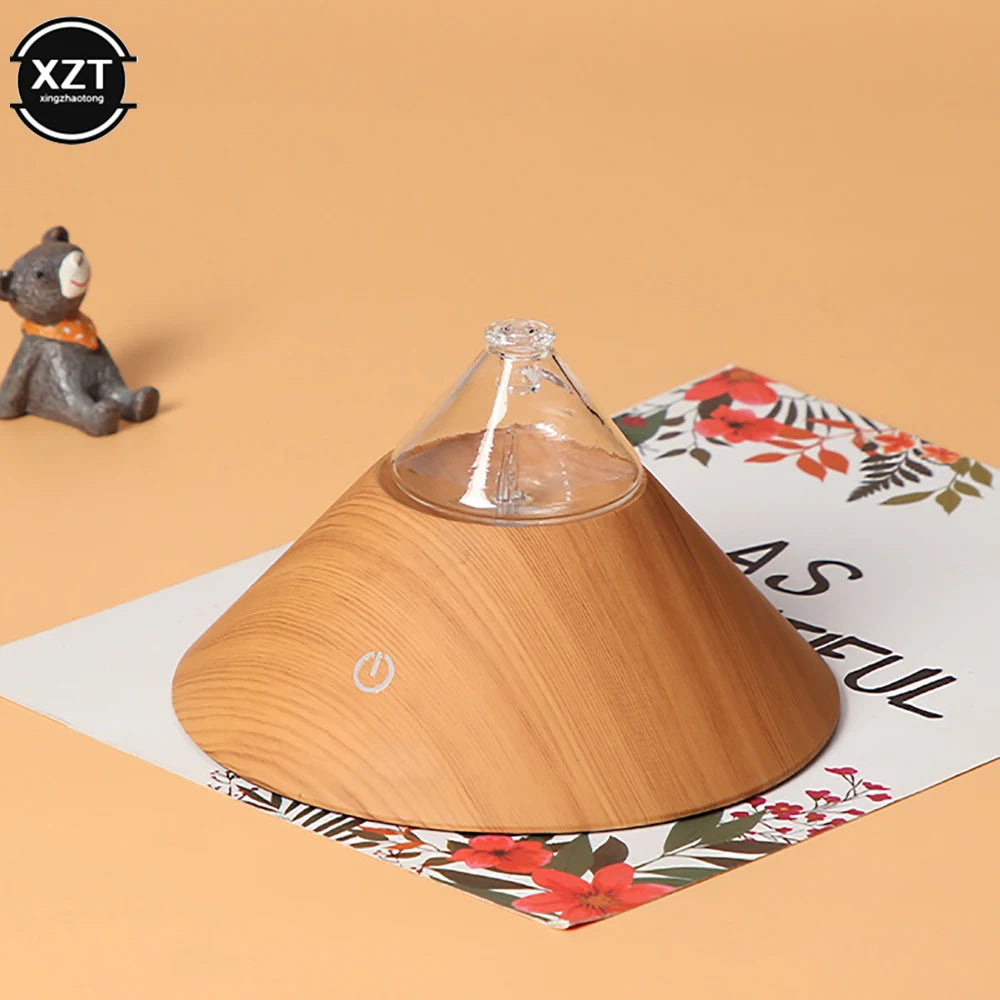 Wood grain compact aroma diffuser with clear glass top and power icon on floral mat