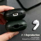 Black eco-leather AirPods case with charging port cutout; earbuds shown