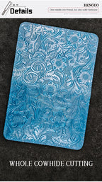 Blue embossed leather travel folio with detailed floral-and-vine pattern, flat view.