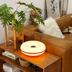 Soft white donut table lamp with center cutout on a wooden side table
