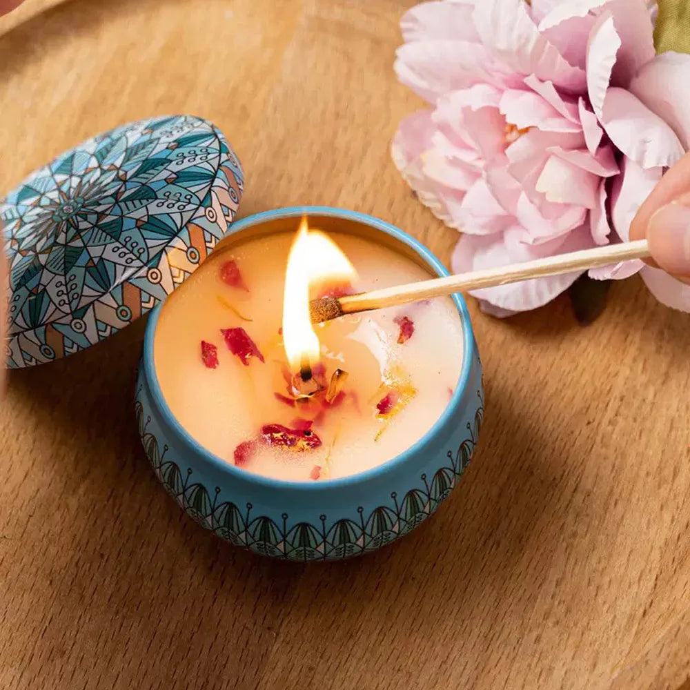Blue tin floral aromatherapy candle with dried petals, lit wick