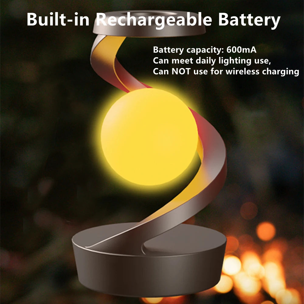 Floating rechargeable lamp with yellow glowing orb and curving suspension arms, dark gray base