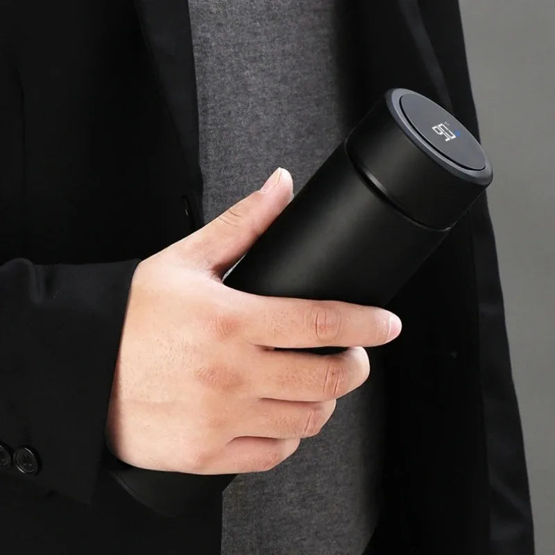 Black insulated thermos bottle with black lid and digital temperature display in hand