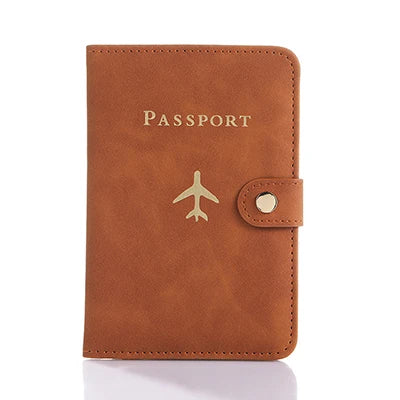Cognac brown passport folio with “PASSPORT” text, airplane emblem, and snap strap