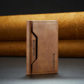 Brown slim leather wallet with stitched front panel and brand logo.