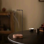 Inverted wooden incense tray with round wood base and tall black metal incense stand