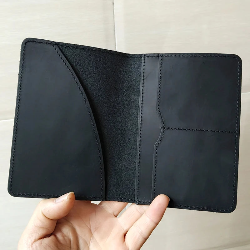Midnight black leather passport cover open, with card slots and contrast stitching