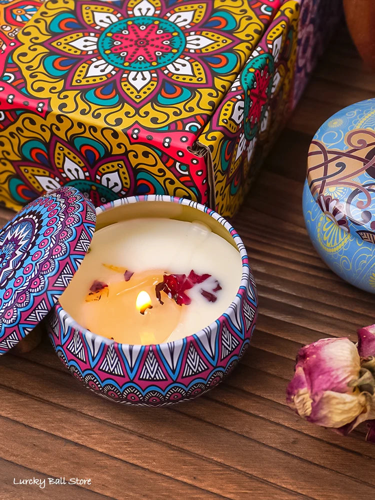 Lit scented candle in blue patterned tin with red and purple wax accents