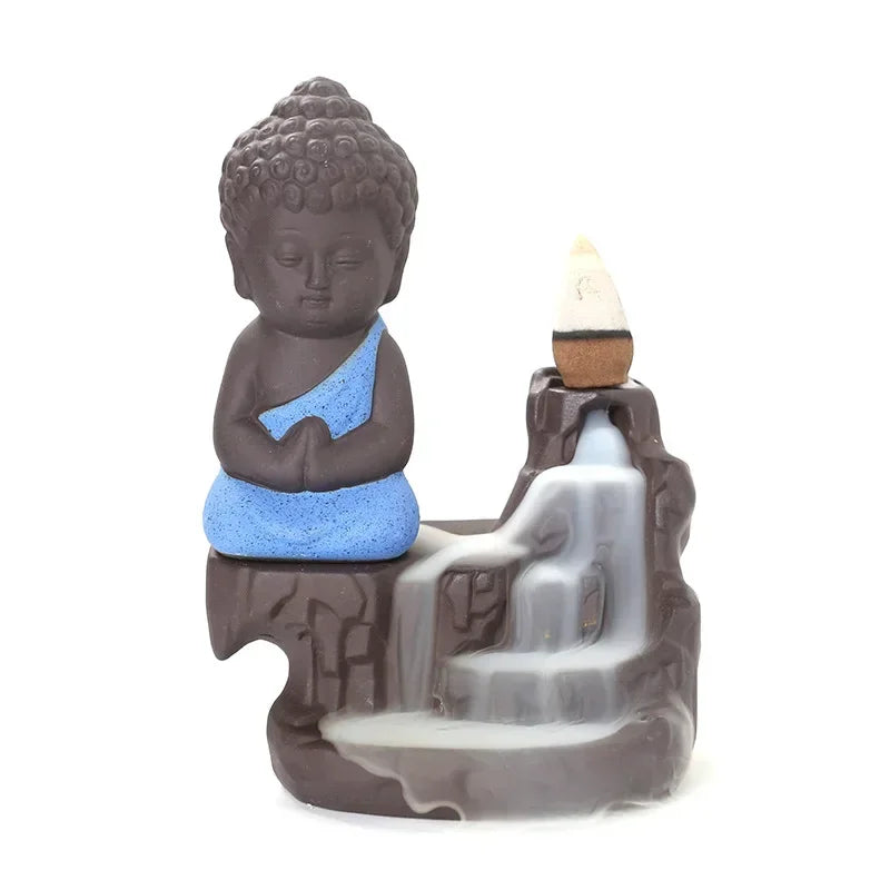 Backflow incense burner front view, blue-robed Buddha beside smoke fountain